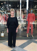 Lataa video gallerian katseluohjelmaan Videolla esitellään jumpsuitin leveät hihat ja takahalkio.
